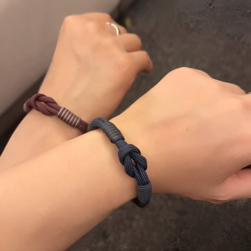 Bracelet cordon nœud modèle Indigo en bleu foncé avec petit mousqueton et bracelet marron noué au poignet.