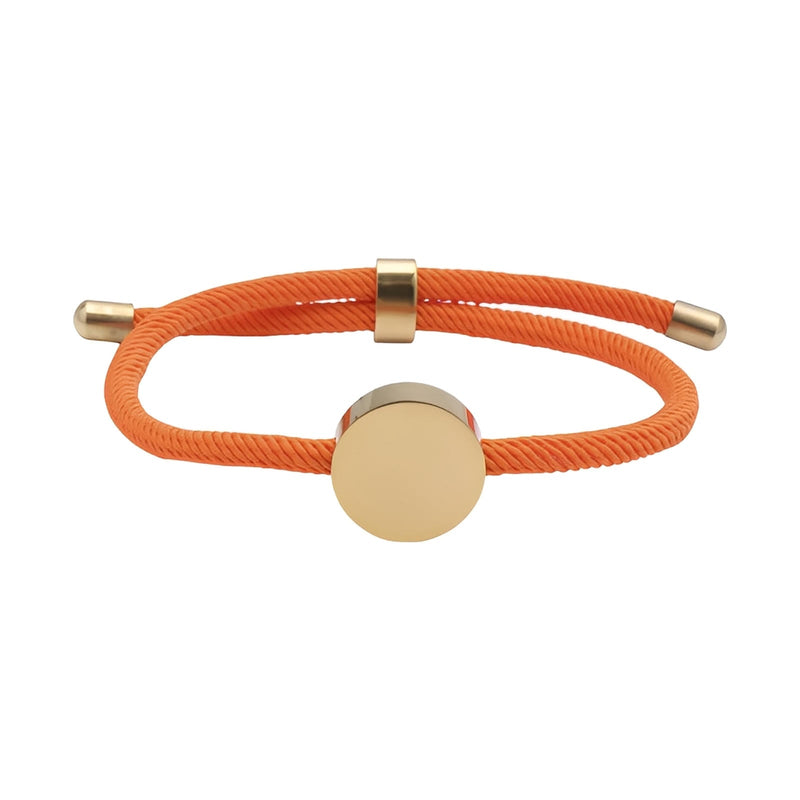 Bracelet cordon orange avec médaillon rond en acier inoxydable doré, style minimaliste et ajustable.