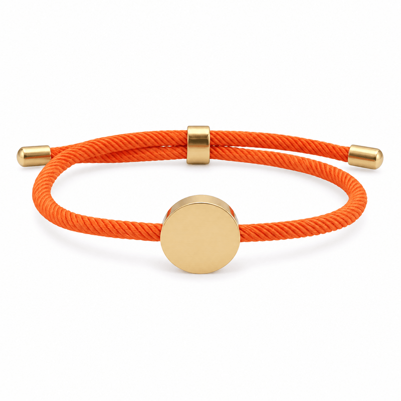 Bracelet Dax Or / Orange, cordon ajustable et médaillon rond, posé de face sur fond blanc