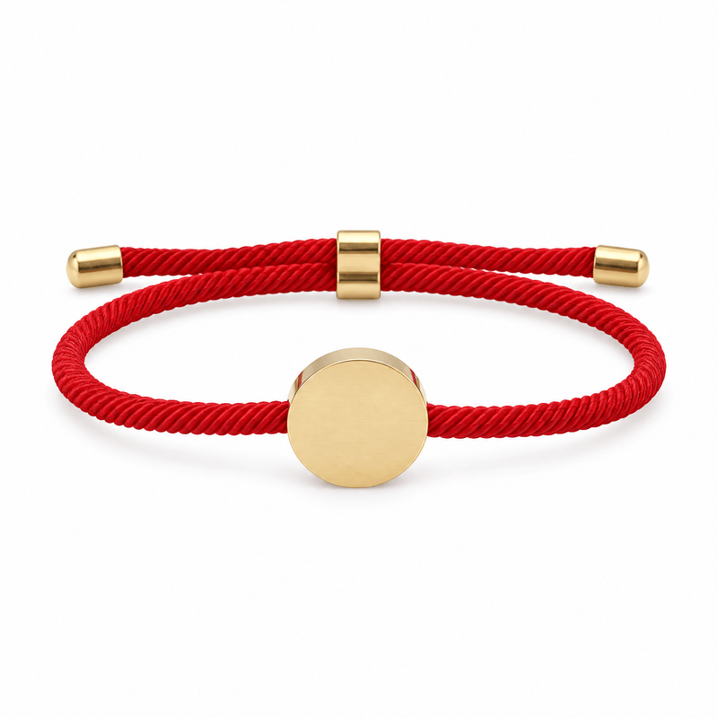 Bracelet Dax Or / Rouge, cordon ajustable et médaillon rond, posé de face sur fond blanc
