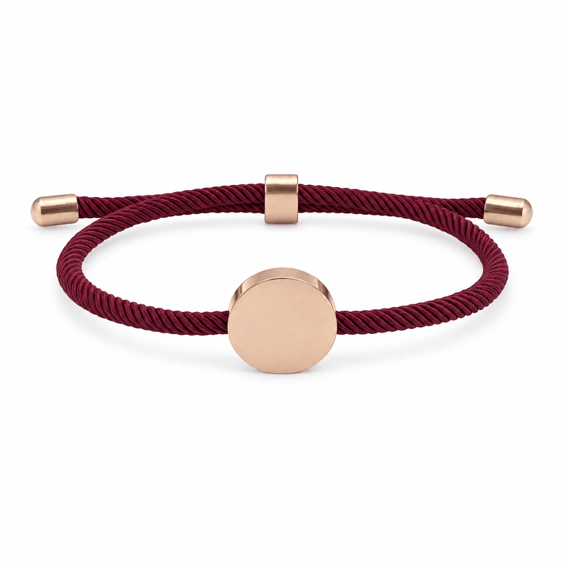 Bracelet Dax Or rosé / Bordeaux, cordon ajustable et médaillon rond, posé de face sur fond blanc
