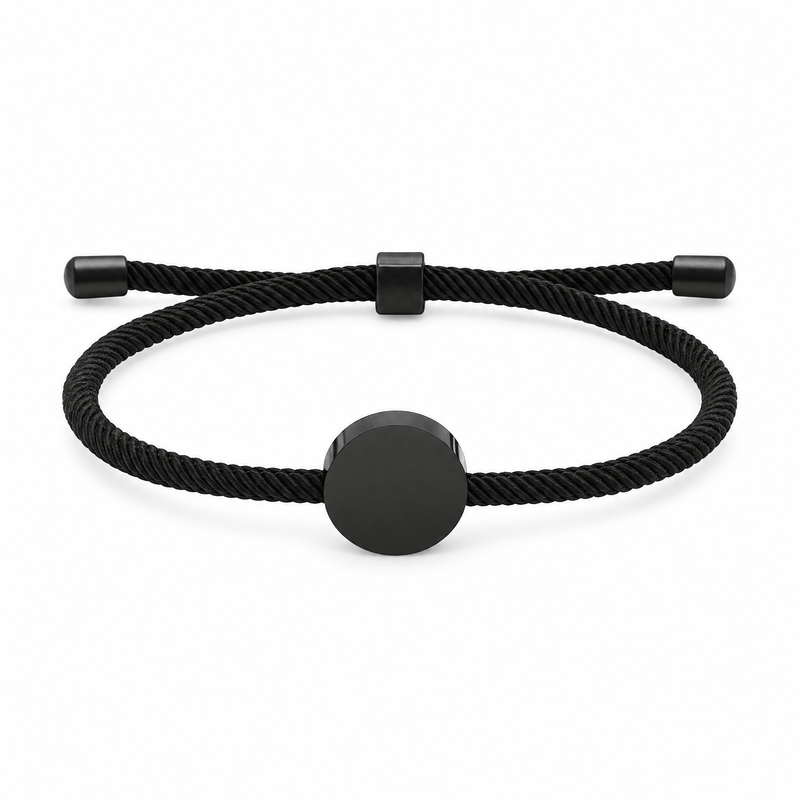 Bracelet Dax Noir / Noir, cordon ajustable et médaillon rond, posé de face sur fond blanc