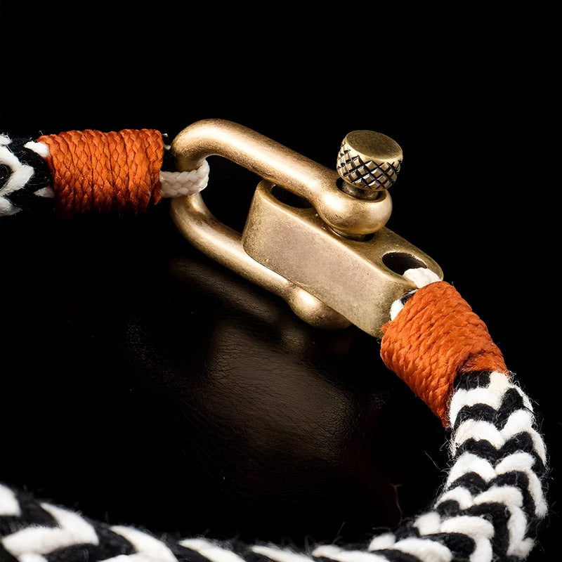 Bracelet cordon noir et blanc avec fermoir mousqueton ancien en métal doré et cordon orange noué.