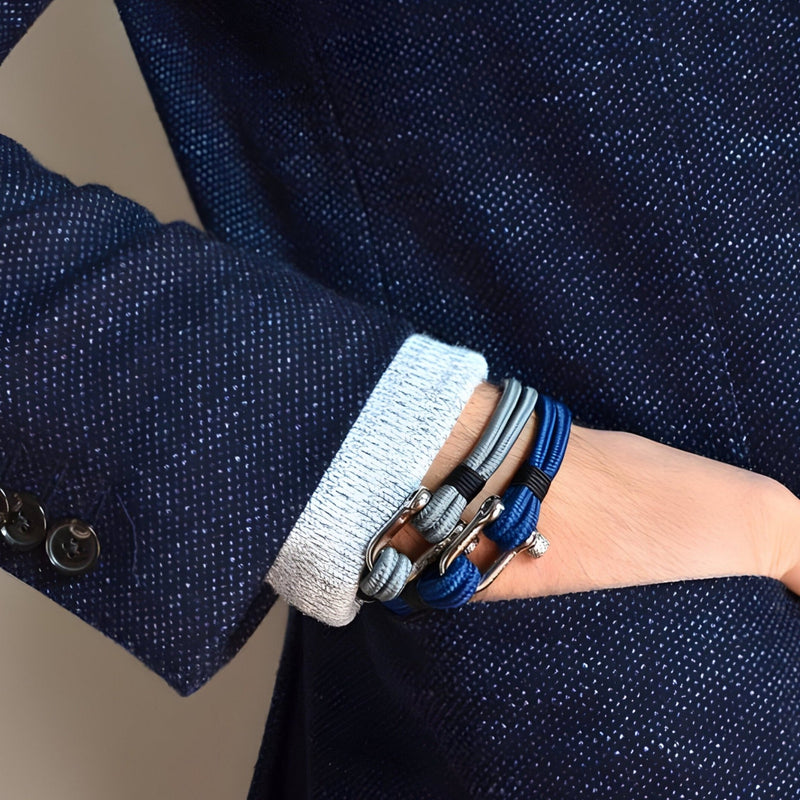 Bracelet cordon bleu homme avec mousqueton argenté et détails en cuir noir et marron.