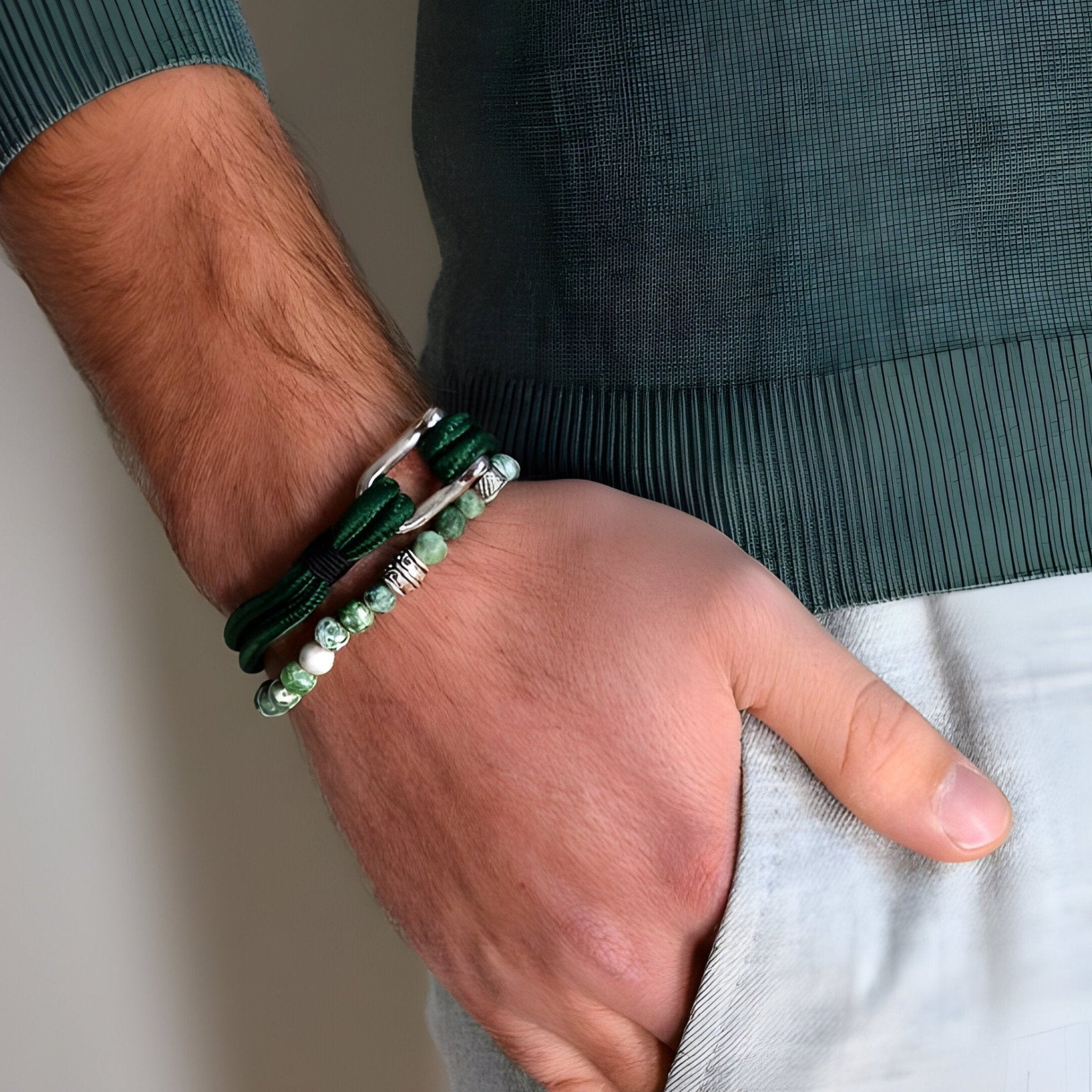 Bracelet cordon vert avec mousqueton argenté porté avec bracelet de perles vert clair.
