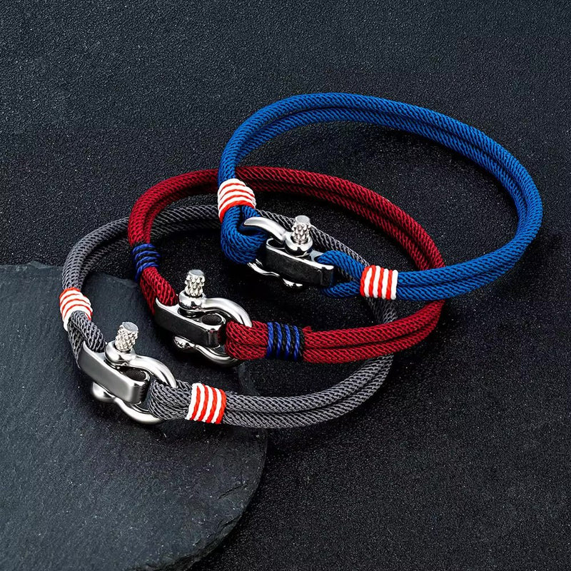Trois bracelets cordon bleu marine, bordeaux et gris avec manilles en acier inoxydable et détails rouges et blancs.