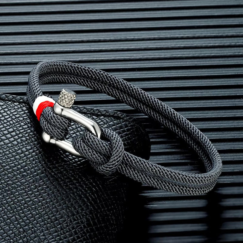 Bracelet cordon noir pour homme avec manille en acier inoxydable et détail rouge blanc.