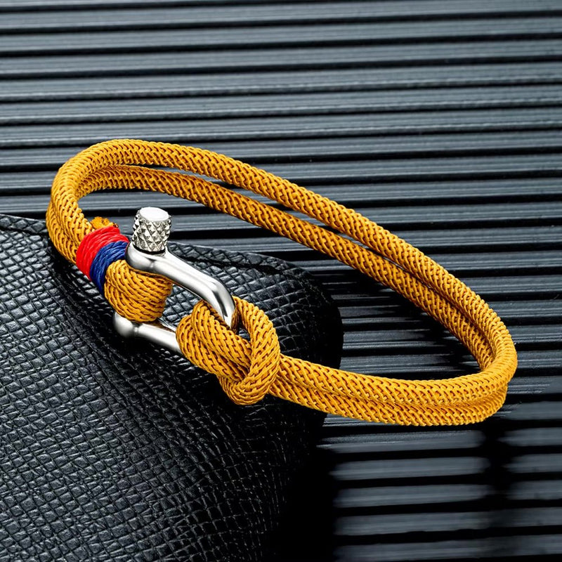 Bracelet pour homme en cordon orange avec manille en acier inoxydable argenté et détail bleu et rouge.