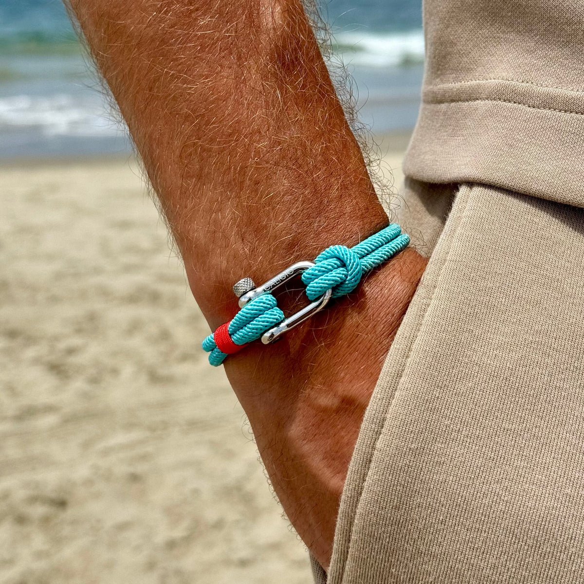 Bracelet cordon turquoise pour homme avec mousqueton argenté et détail rouge, style marin.