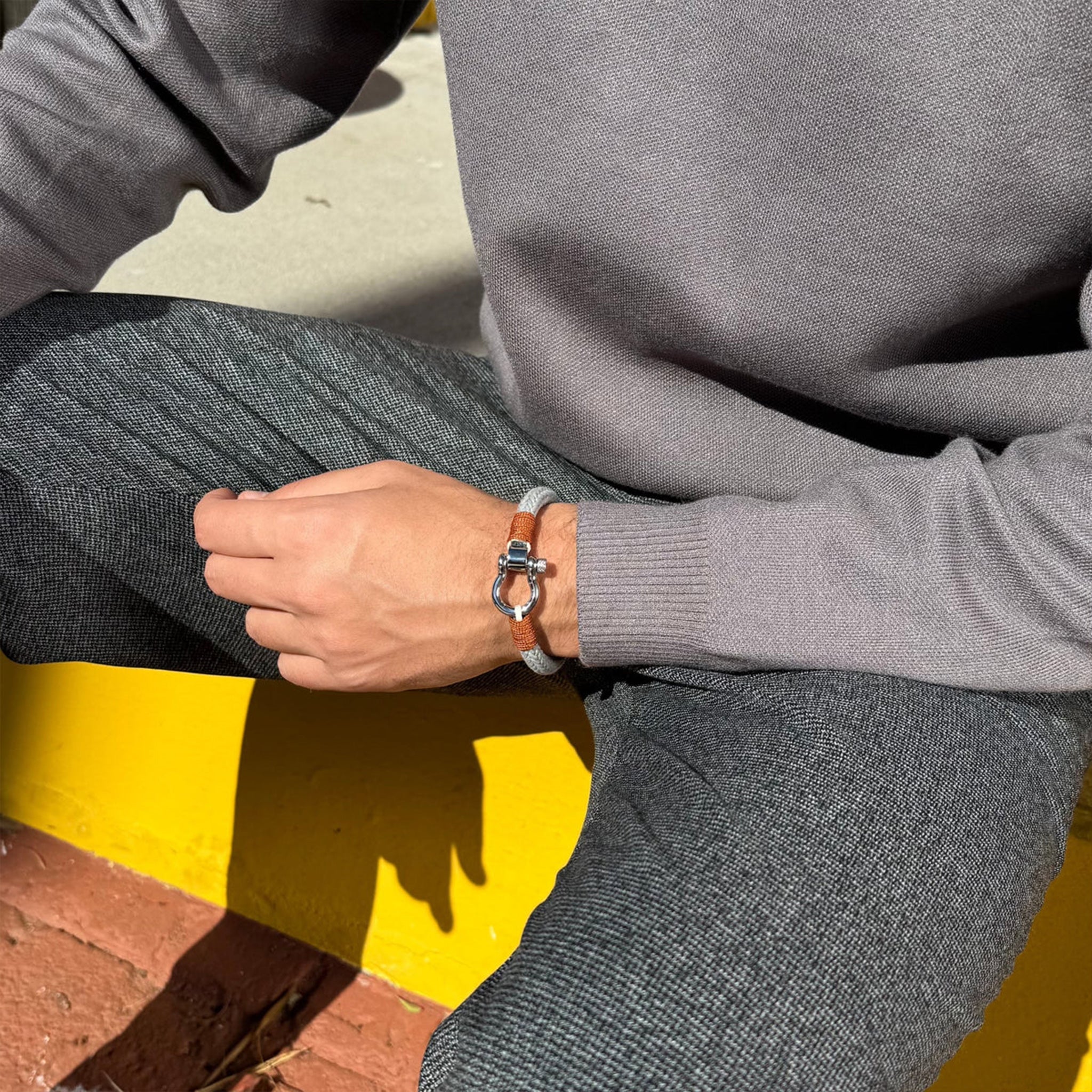 Bracelet cordon gris avec mousqueton arrondi en métal, style masculin et moderne.