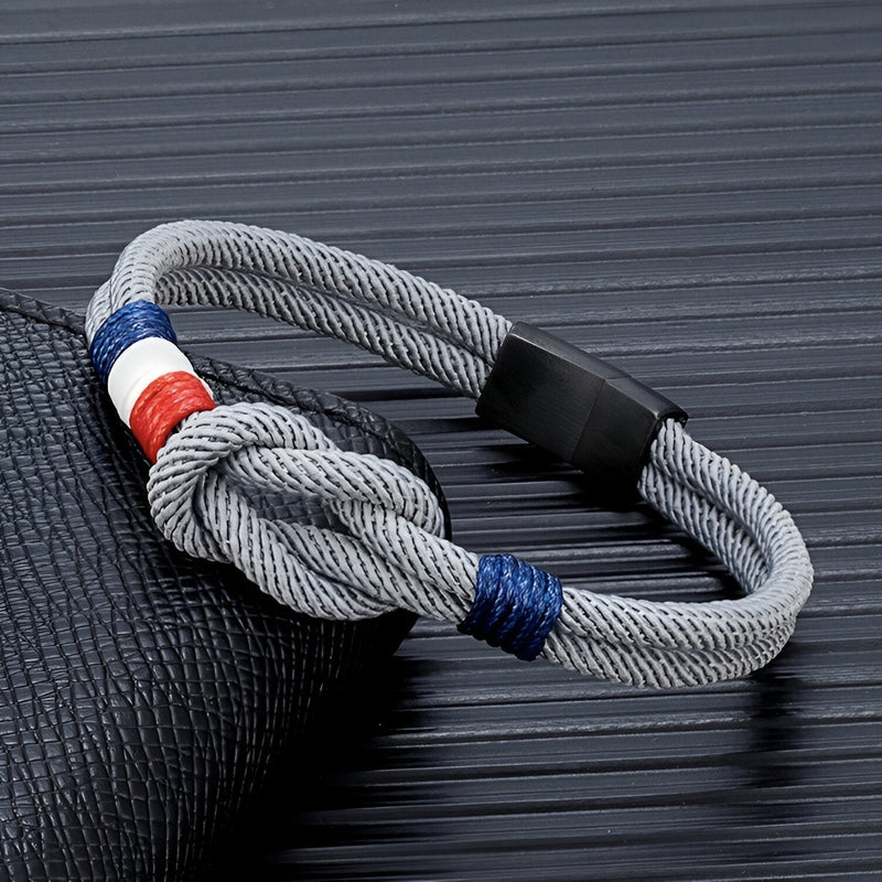 Bracelet cordon gris clair avec nœud et drapeau français, fermoir noir mat.
