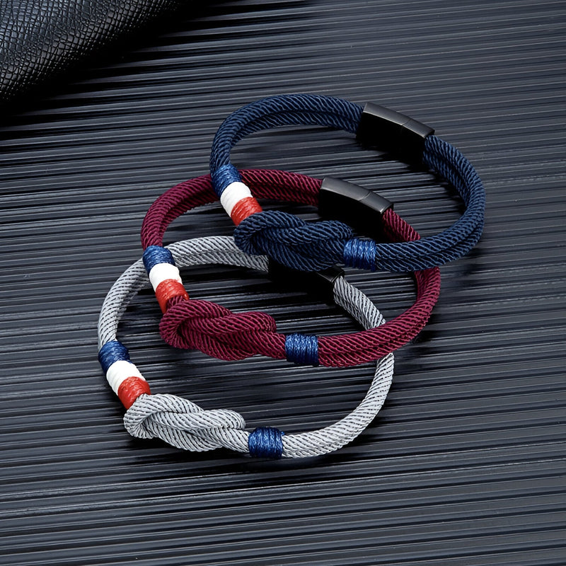 Bracelets cordon noués en bleu marine, bordeaux et gris avec détail drapeau français en tissu.