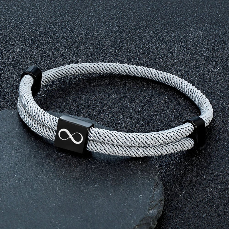 Bracelet cordon gris argenté avec plaque noire en acier inoxydable gravée d’un signe infini.