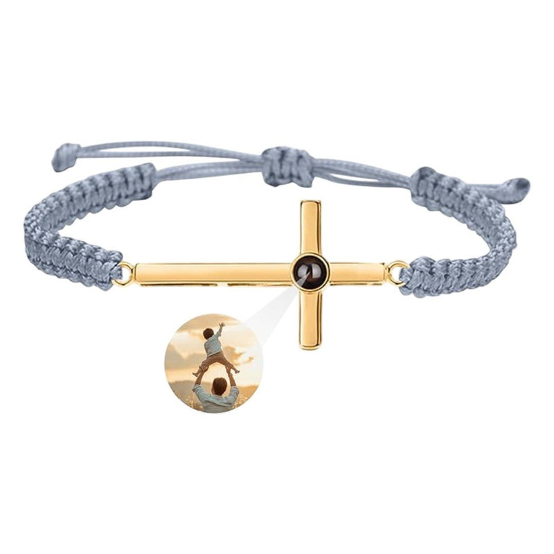 Bracelet à corde grise coulissante avec pendentif croix en argent doré et centre noir gravé.