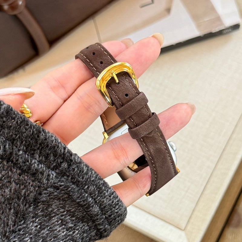 Bracelet en cuir marron foncé pour Apple Watch avec boucle dorée brillante et coutures visibles.