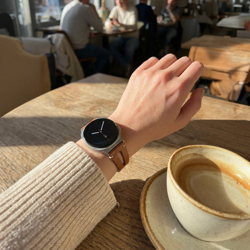 Bracelet en cuir souple beige pour Galaxy Watch 8 et Ultra 47mm avec fermeture boucle classique, porté au poignet féminin.