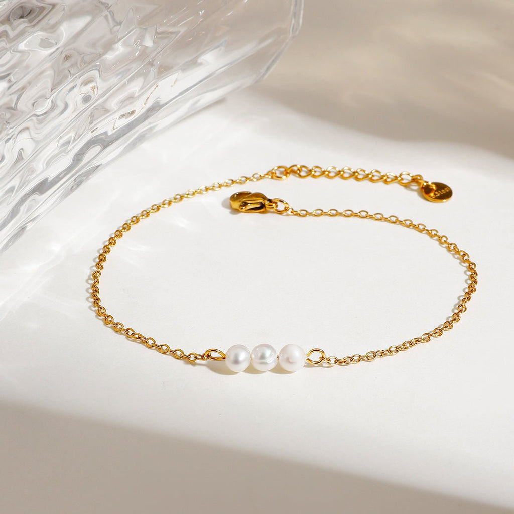 Bracelet de cheville or fin à double rang avec trois perles d'eau douce blanches et chaîne délicate en acier inoxydable.