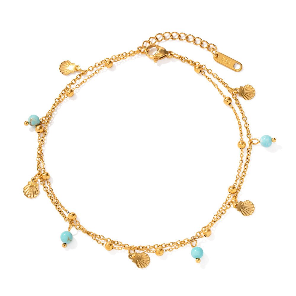 Bracelet de cheville double rang en acier inoxydable doré, ornée de perles turquoises et petits pendentifs coquillage.