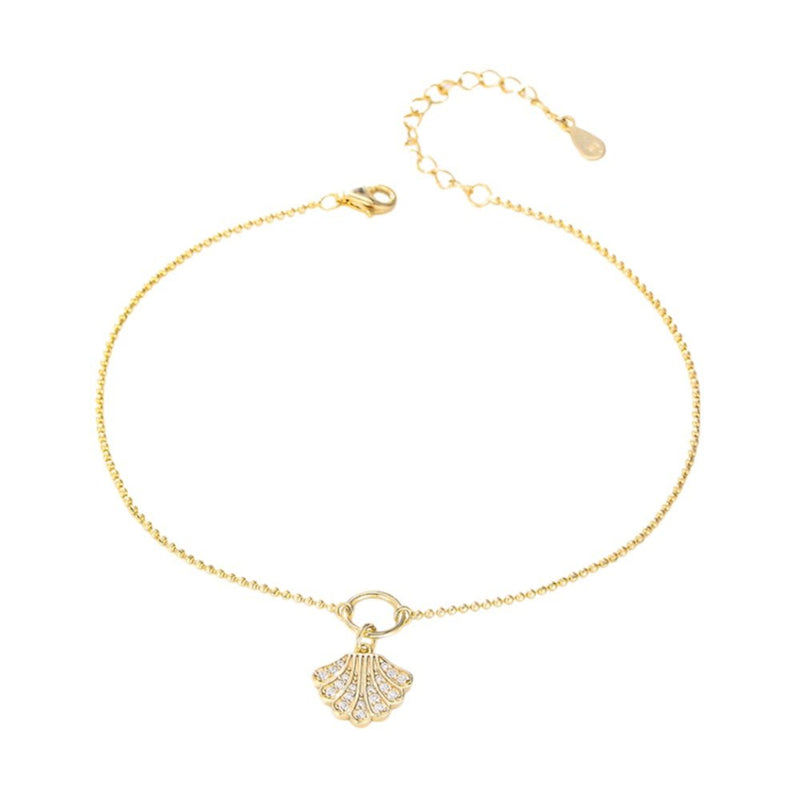 Bracelet de cheville en chaîne fine dorée avec pendentif coquillage en argent serti de petits cristaux.
