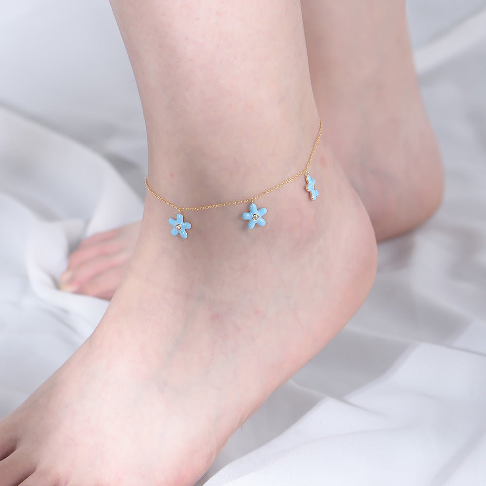 Bracelet de cheville en argent sterling avec trois petites fleurs bleues suspendues délicates.