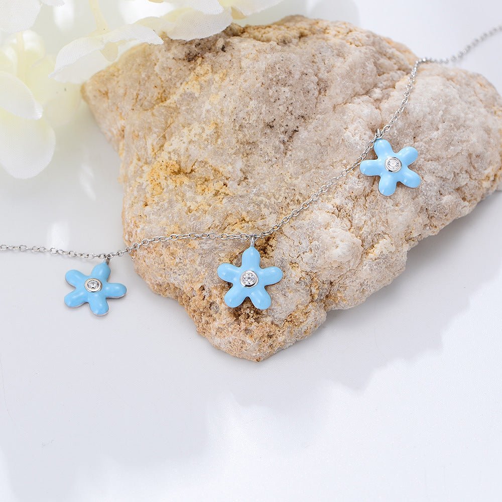 Bracelet de cheville argent sterling avec fleurs bleues et petits cristaux au centre.