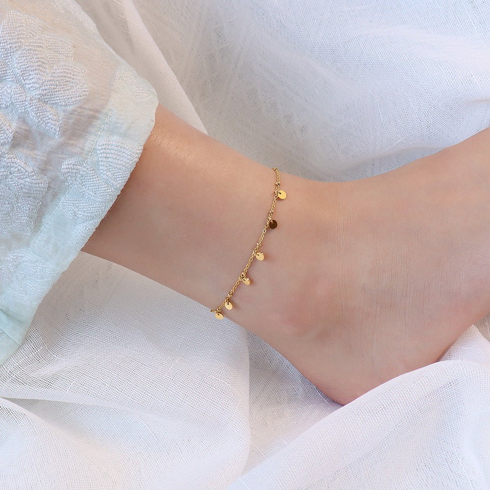 Bracelet de cheville en titane doré avec multiples médaillons ronds suspendus, style délicat pour femme.