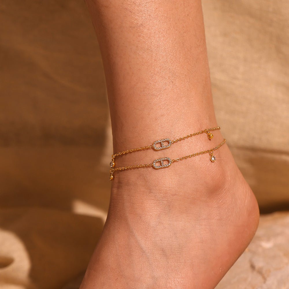 Bracelet de cheville en titane doré, double chaîne fine avec petits zirconiums étincelants.