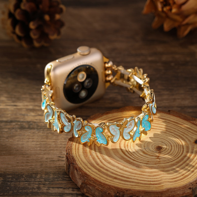 Bracelet Apple Watch doré avec motif papillons bleus et blancs style Florencia.