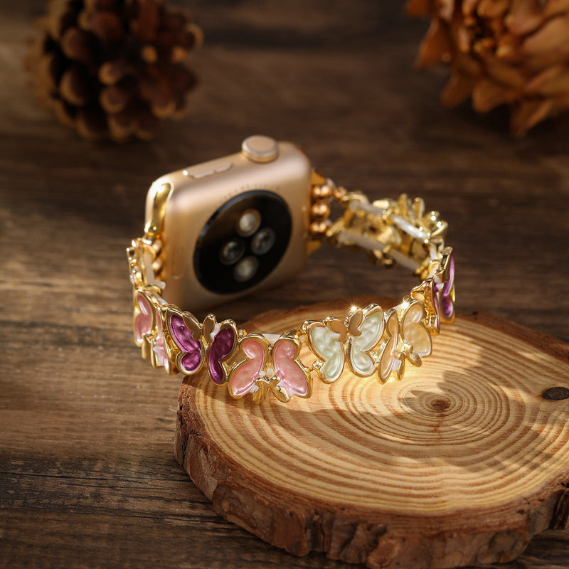Bracelet Apple Watch en métal doré à motifs papillons multicolores délicats pour femme.