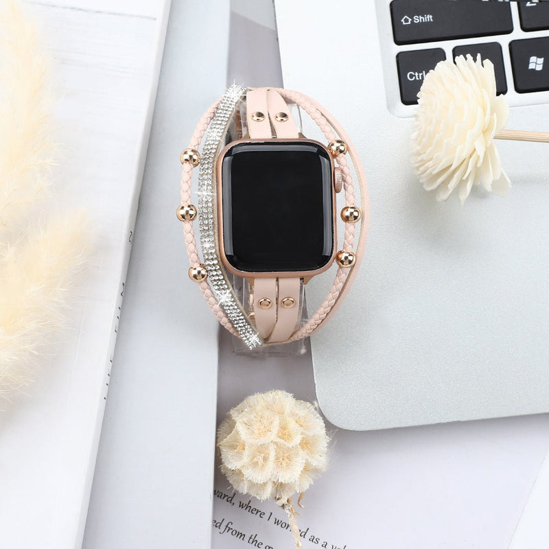 Bracelet Apple Watch rose avec strass scintillants et détails métalliques élégants, style double tour.