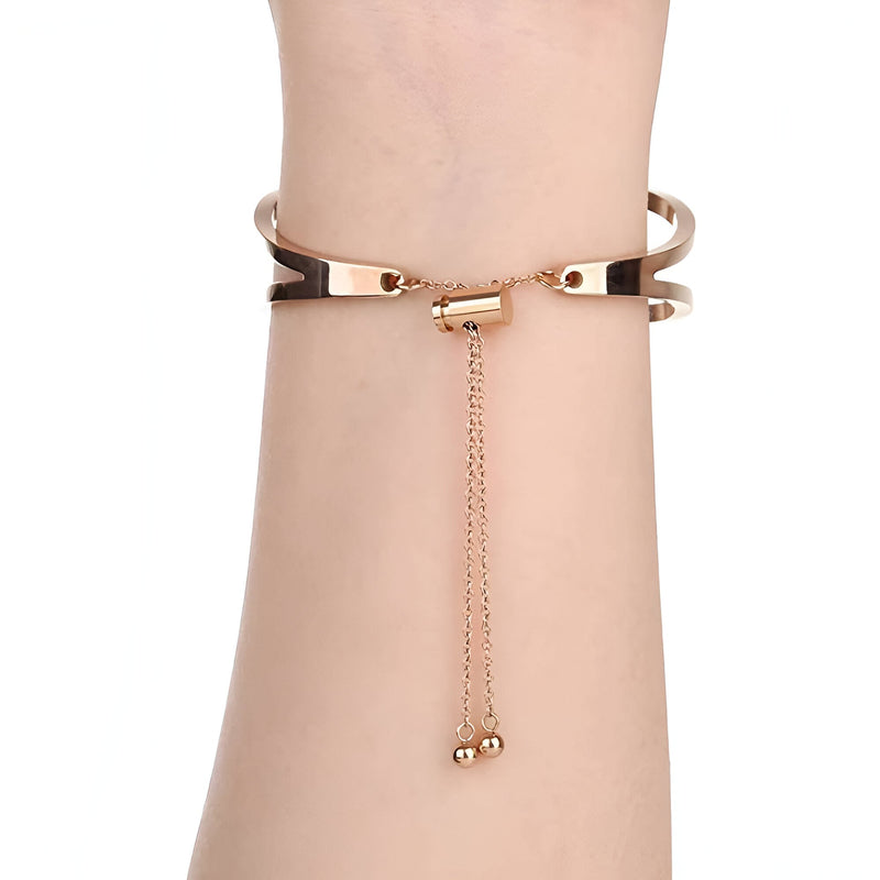 Bracelet pour femme en acier inoxydable or rosé, style manchette avec chaîne réglable et finition lisse.