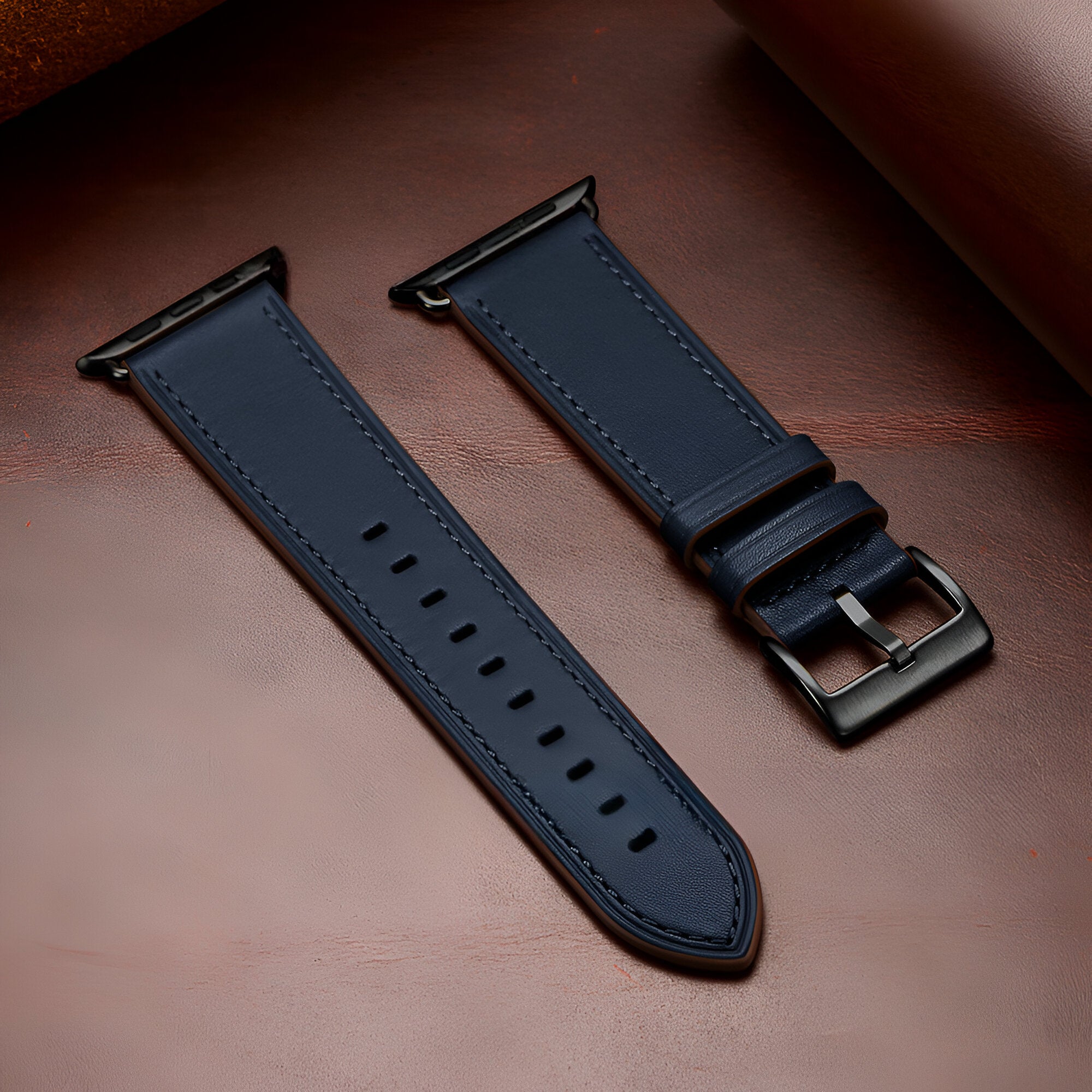 Bracelet Apple Watch en cuir bleu marine, boucle métallique noire, style épuré et élégant.