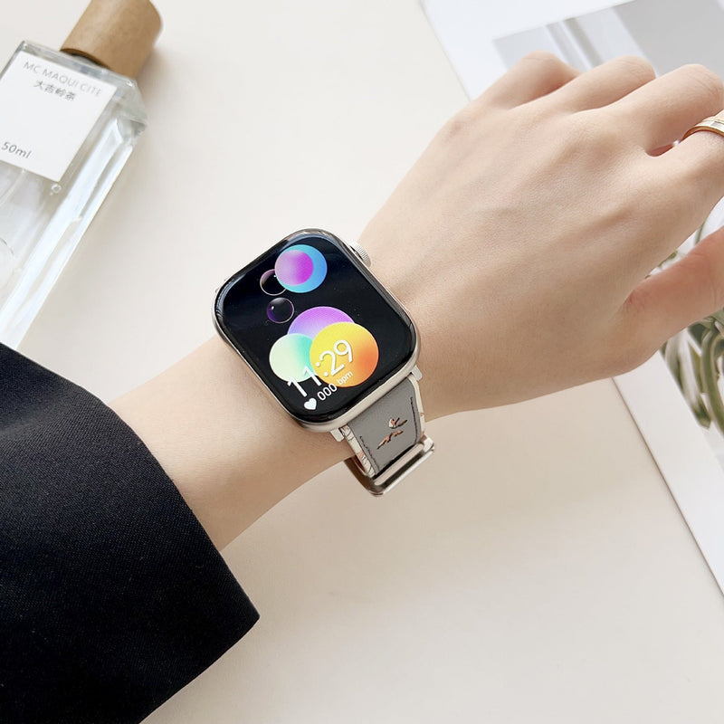 Bracelet Apple Watch en cuir beige avec motif papillons, lacet fin et boucle argentée.