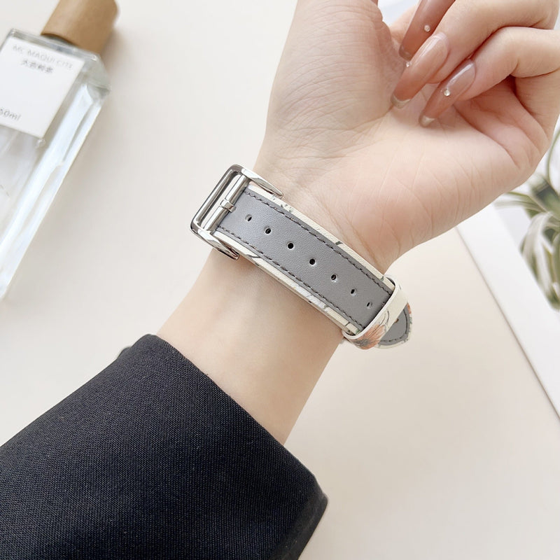 Bracelet cuir gris motif papillons pour Apple Watch, boucle argentée, style féminin élégant.