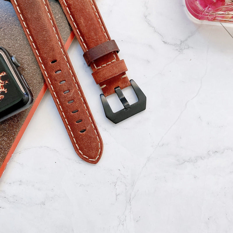 Bracelet Apple Watch en cuir marron avec surpiqûres blanches et boucle noire matte.