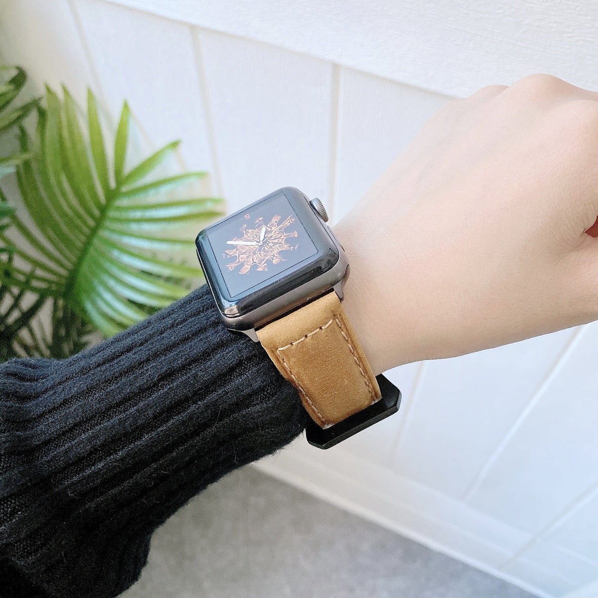 Bracelet Apple Watch en cuir beige pour femme, modèle Brae, porté au poignet.