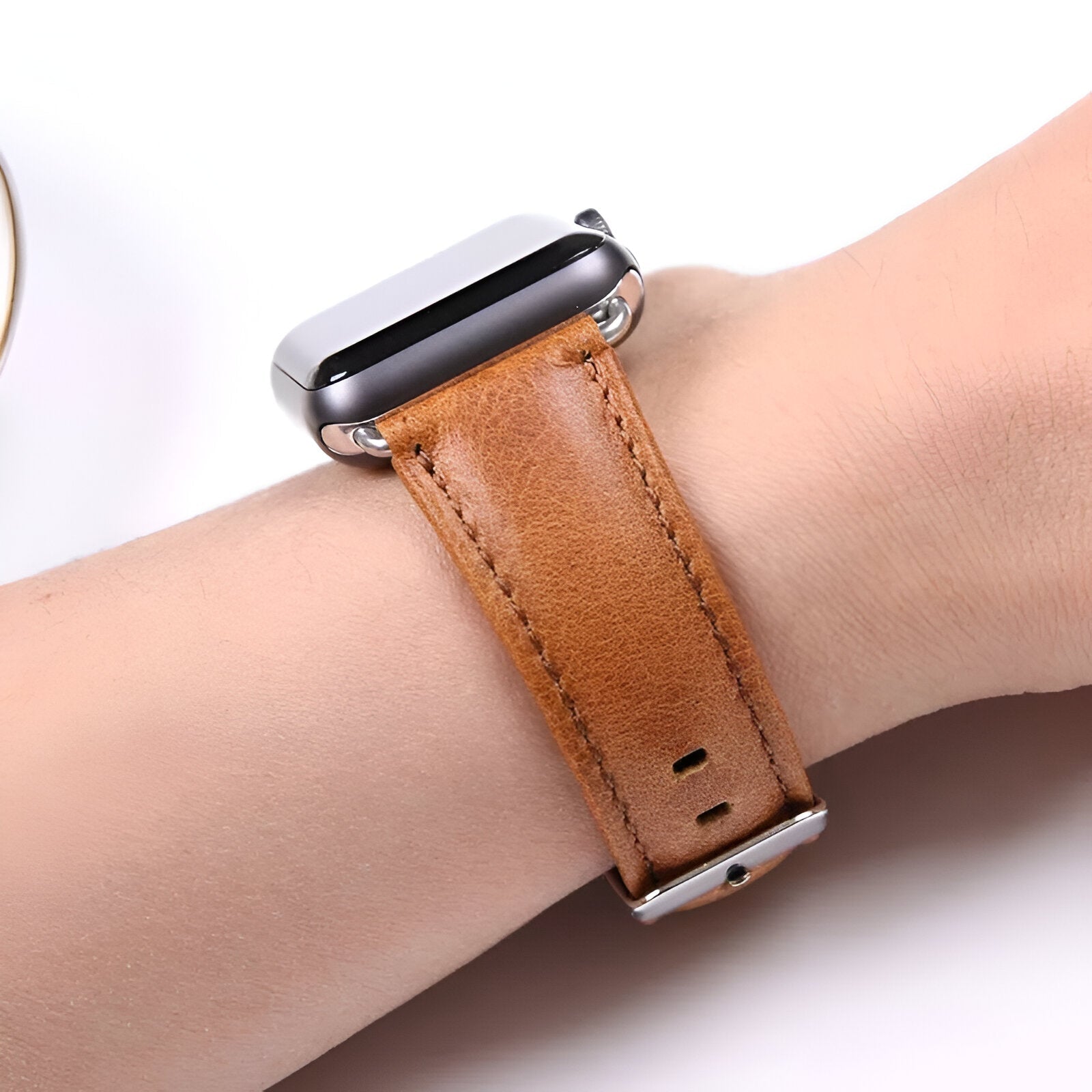 Bracelet Apple Watch en cuir marron clair avec boucle argentée, style Bryzo, porté au poignet homme.