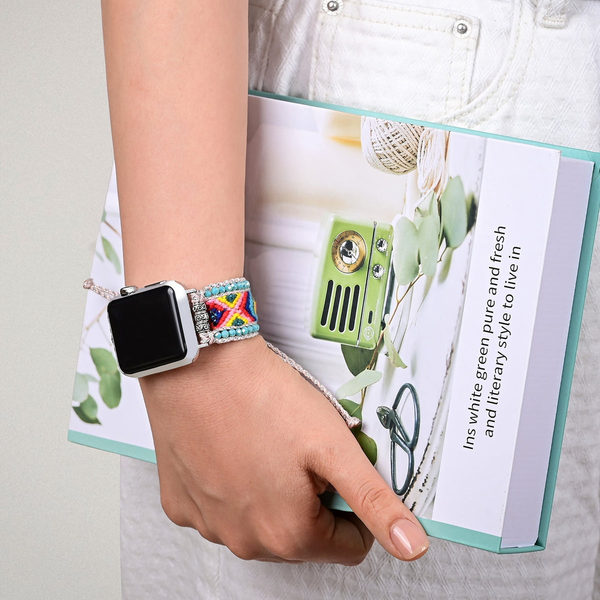 Bracelet Apple Watch féminin en nylon multicolore tissé avec détails en cristal, modèle Pyxis, porté au poignet.