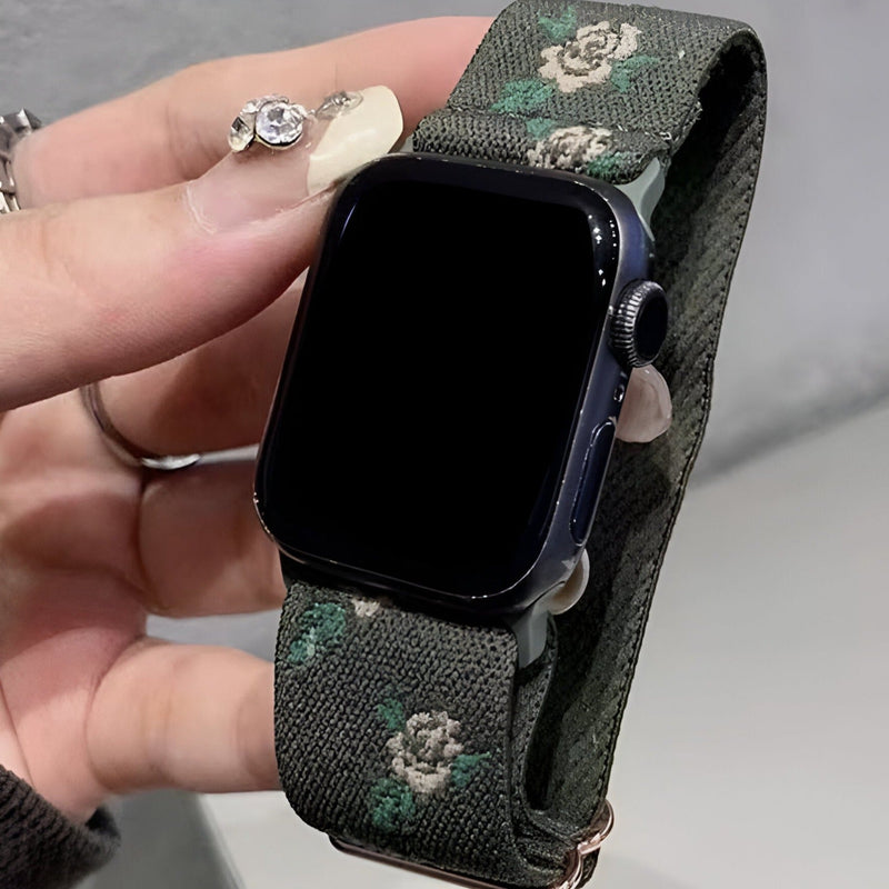 Bracelet Apple Watch en nylon kaki avec motifs floraux blancs, boucle noire élégante.