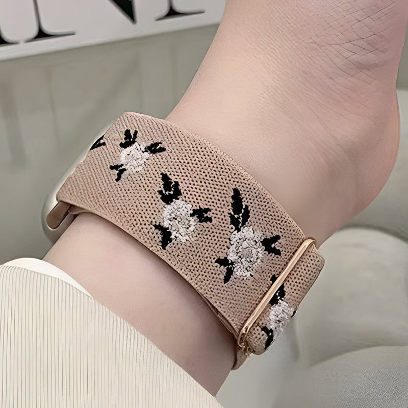 Bracelet Apple Watch en nylon beige à motifs floraux blancs et noirs, boucle dorée rose.