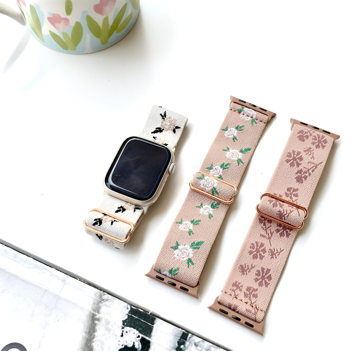 Bracelet Apple Watch en nylon beige clair à motifs floraux blancs et roses, style élégant pour femme.