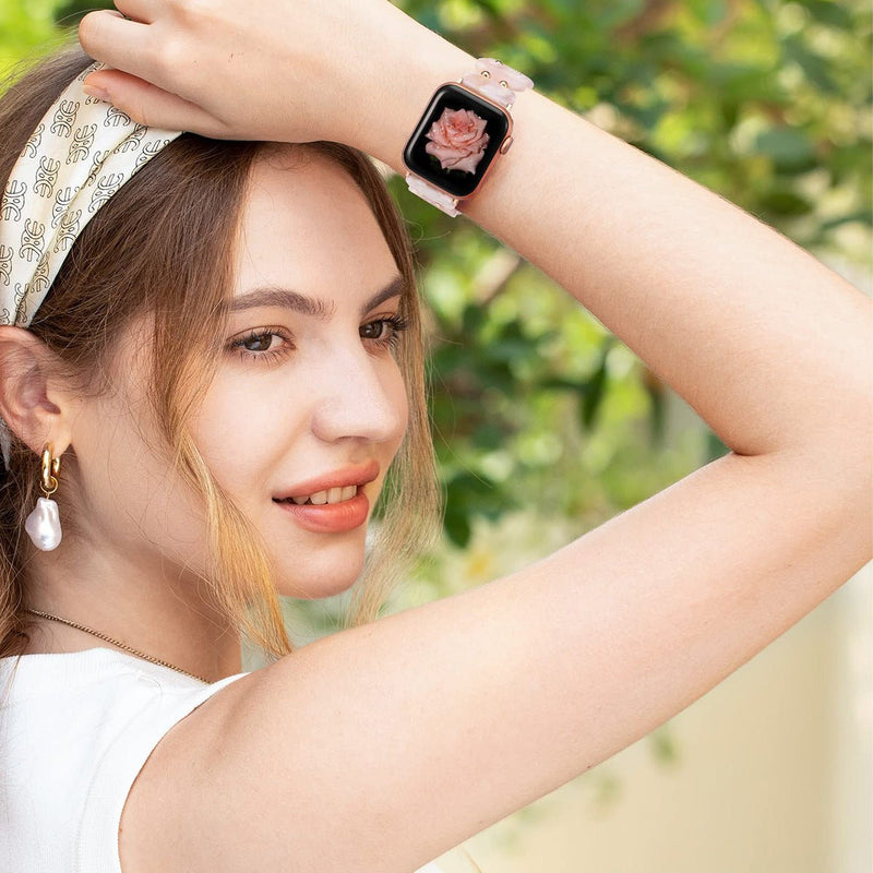 Bracelet Apple Watch en résine beige avec motif sauvage, porté au poignet d'une femme blonde à l'extérieur.