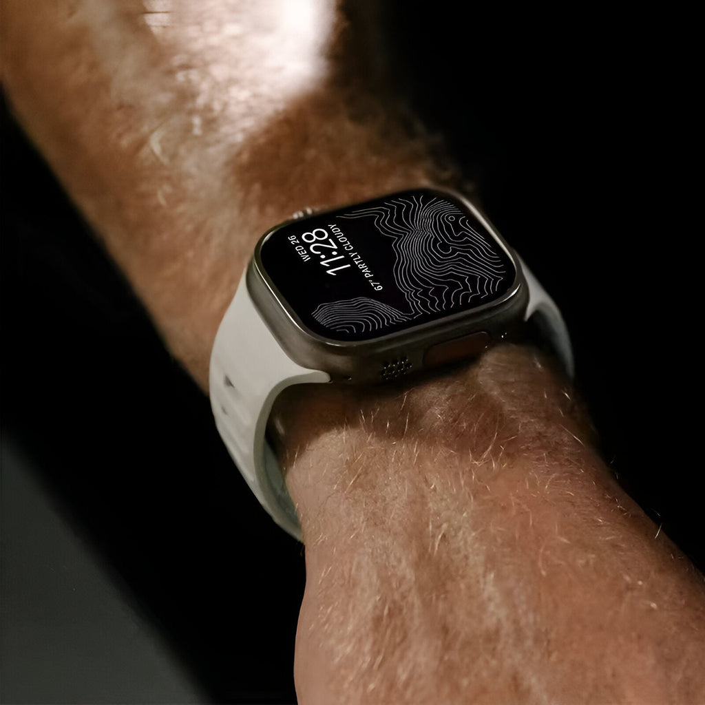 Bracelet Apple Watch en silicone blanc phosphorescent, style sport, modèle Kelan, porté au poignet homme.
