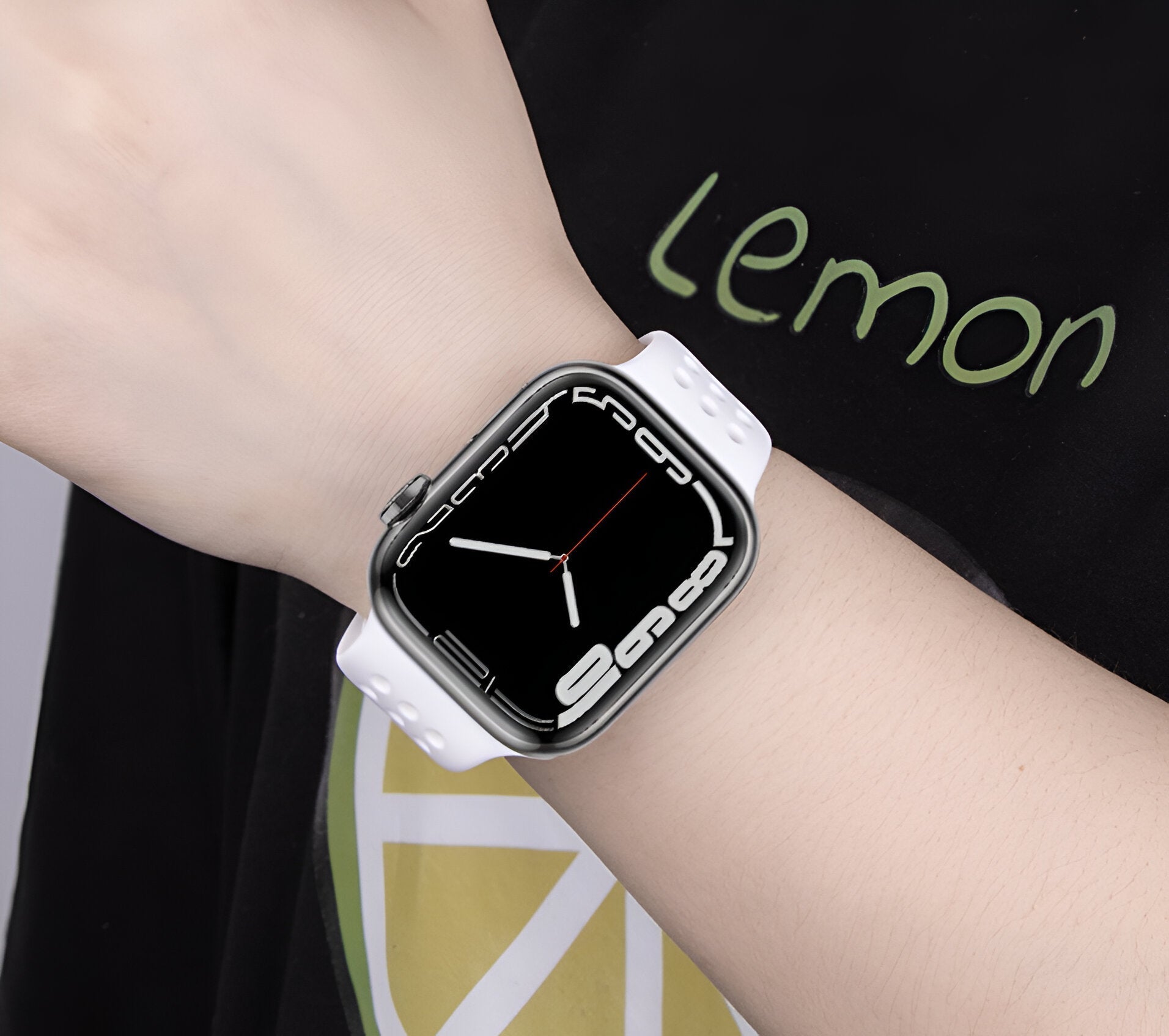 Bracelet Apple Watch en silicone blanc finition lisse porté au poignet femme.