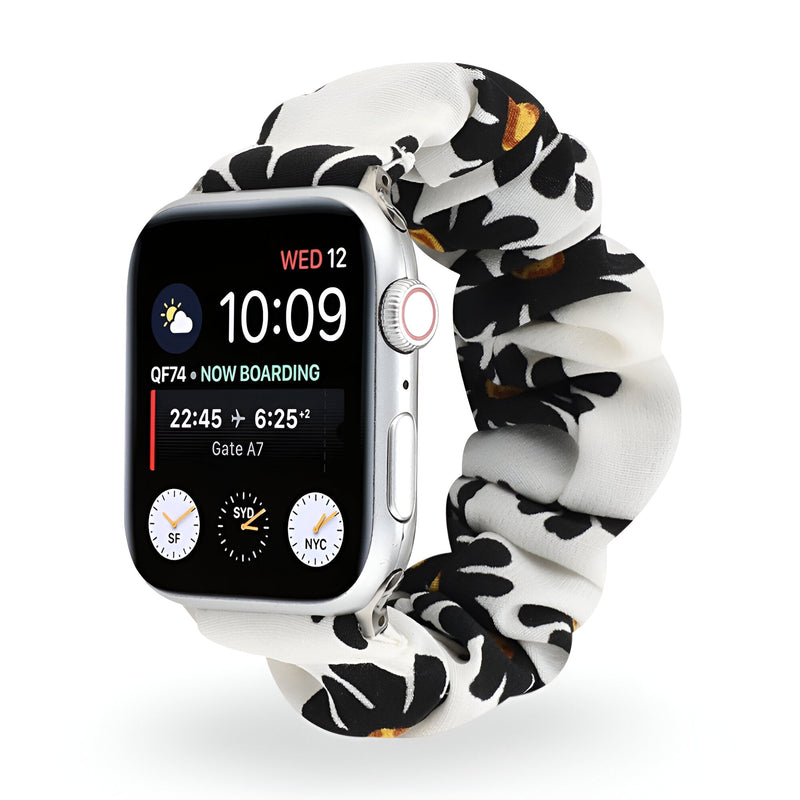Bracelet Apple Watch en tissu élastique blanc à motif floral noir et orange, style scrunchie.