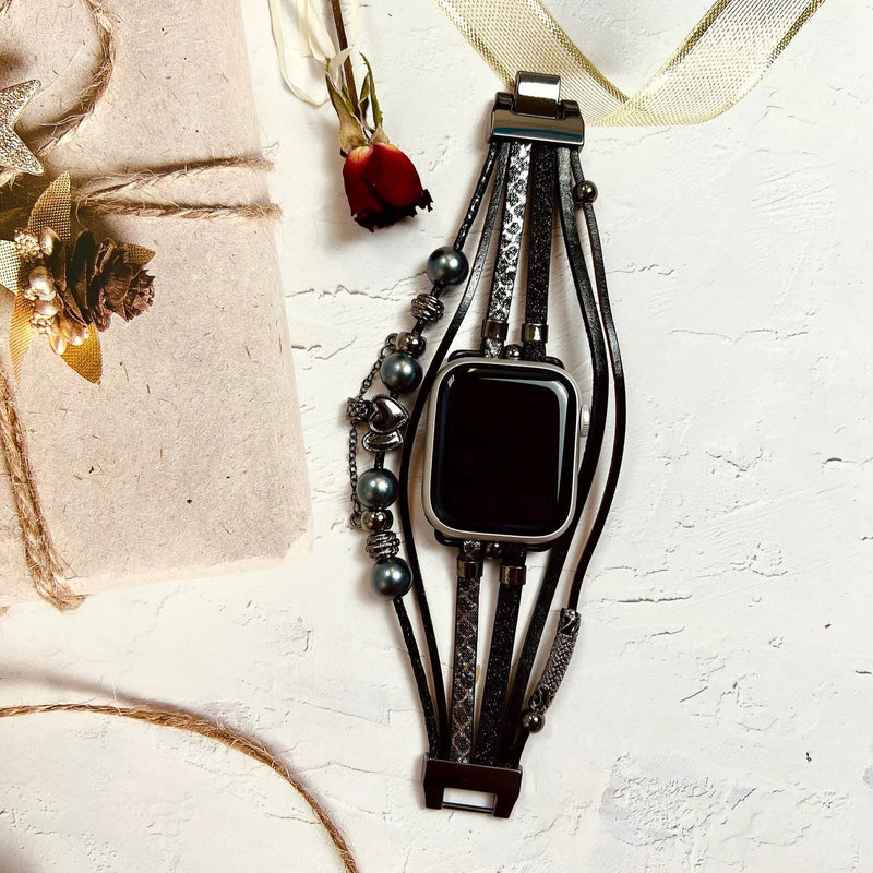 Bracelet Apple Watch multi-rangs noir avec perles et charms métalliques élégants pour femme.