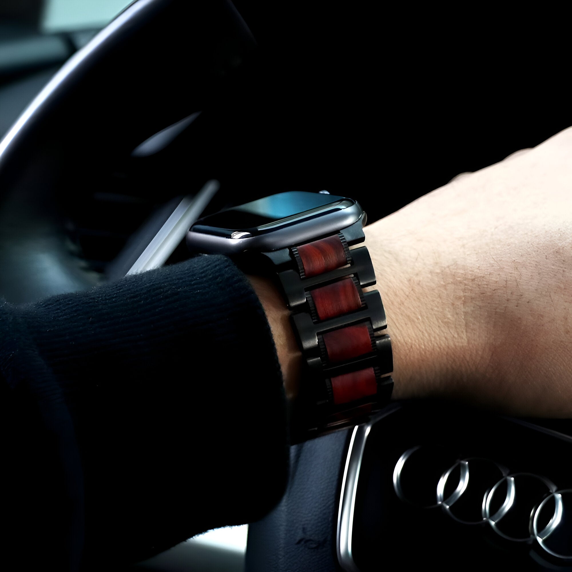 Bracelet de montre en bois de santal rouge et maillons noirs, compatible Apple Watch, porté au poignet homme.