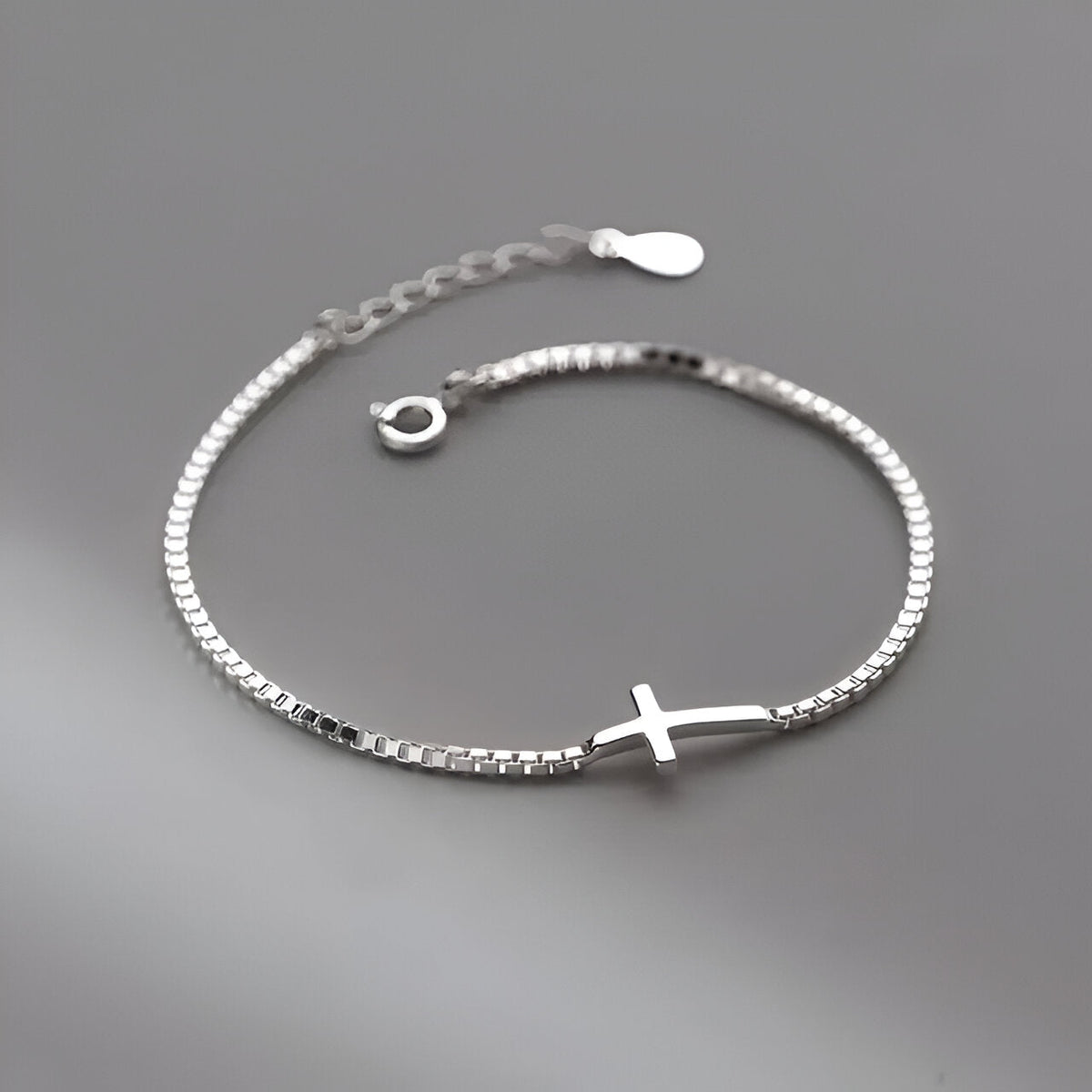 Bracelet fin en argent sterling avec petite croix chrétienne centrale, chaîne délicate ajustable.
