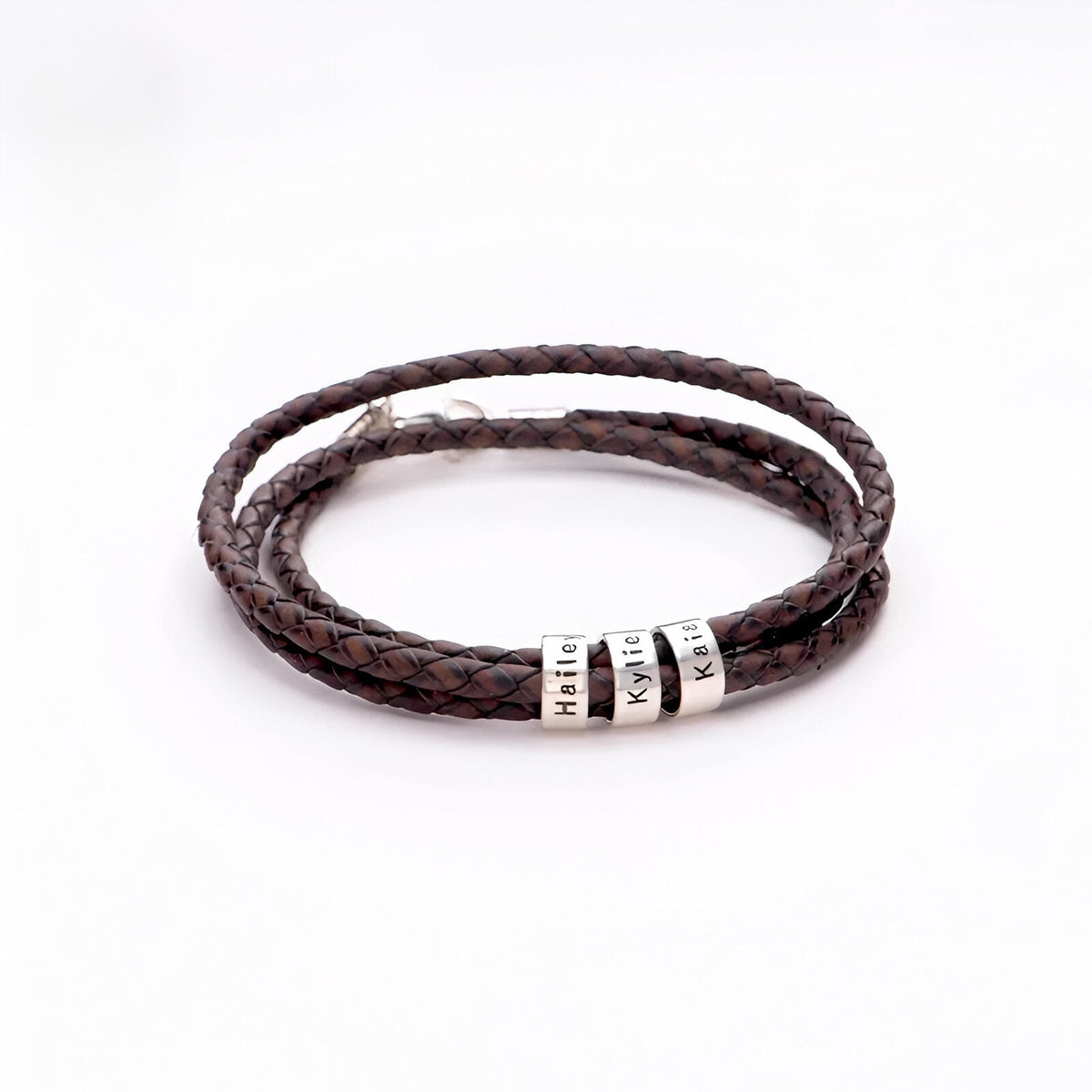 Bracelet double cordon en cuir café tressé avec deux plaques métalliques personnalisées argentées.
