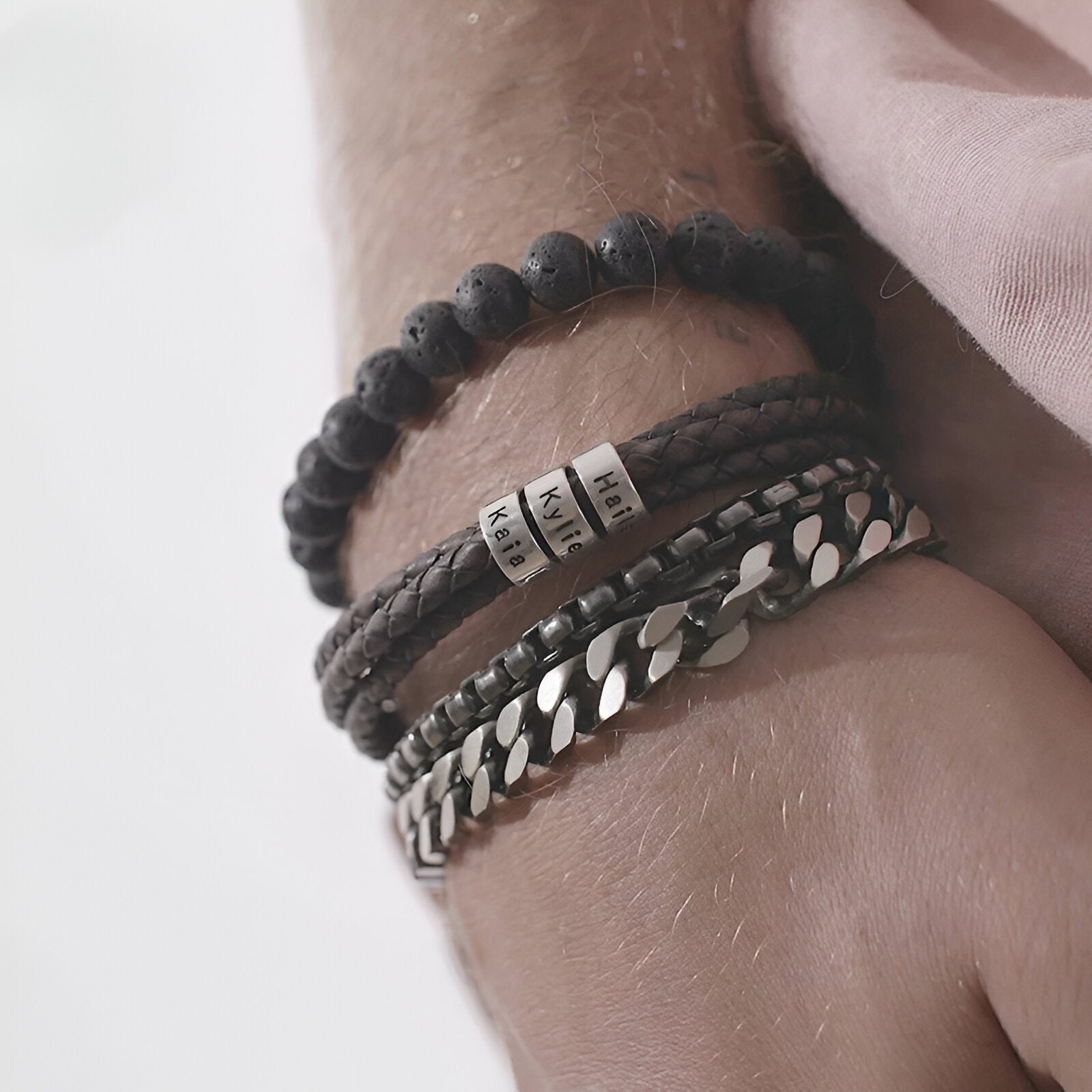 Bracelet homme double cordon cuir noir, trois plaques métalliques arrondies, perles noires et chaîne acier.